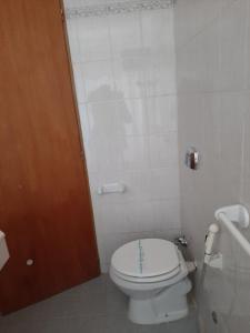玛德琳港LOWCOST MADRYN的浴室设有白色卫生间和棕色门。