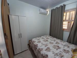 加罗帕巴Casa perto do centro的一间卧室配有床、橱柜和窗户