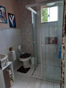 加罗帕巴Casa perto do centro的一间带玻璃淋浴和卫生间的浴室
