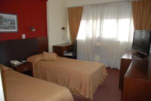 圣罗莎Calfucura Apart Hotel的酒店客房设有两张床和一台平面电视。