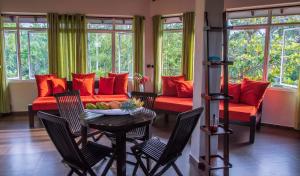 希克杜沃Sophie House的客厅配有红色的沙发、桌子和椅子