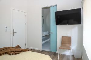 EscazúColina Inn的卧室设有一扇蓝色门,墙上配有电视