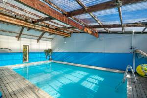 塔卡卡Anatoki Lodge Motel的一个带蓝色墙壁和木制天花板的室内游泳池