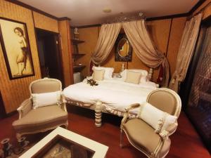 帕佩托艾费努阿马塔伊奥阿酒店的一间卧室配有一张床和两把椅子