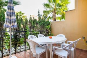 韦尔瓦Dorado Playa的庭院配有桌椅和遮阳伞。