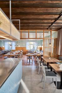 马克多夫Landgasthof Linde Hepbach, Hotel & Restaurant的一间带木桌椅的餐厅和一间酒吧