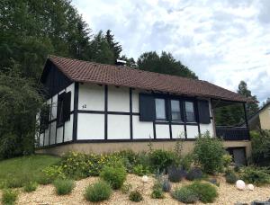 HildersFerienhaus Kolb的白色和黑色的房子,前面有一个花园