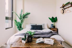 台南海安艺术公寓民宿的一间卧室配有一张床和一张植物桌子