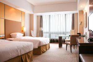 烟台烟台南山皇冠假日酒店的酒店客房设有两张床和一张桌子。