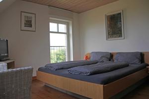 MarlowFerienhaus Polkvitz的一间卧室配有一张带蓝色床单的床和一扇窗户。