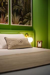卡利亚里Birkin Porto 1870的一间卧室设有绿色的墙壁和一张带心枕的床