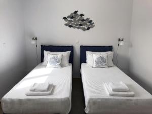迈索尼Bay View Villas的两张睡床彼此相邻,位于一个房间里