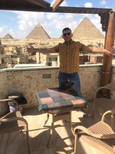 开罗City pyramids inn的站在金字塔前的桌子上的人