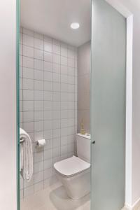 新加坡lyf Farrer Park Singapore的一间带卫生间的浴室和白色瓷砖墙