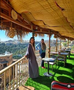 Misfāh阿尔密斯法温馨旅馆的站在阳台上的男女