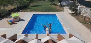 KatuniVilla MirIva的两个人站在游泳池里