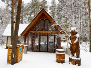 喀山Irbis Hotel的雪中小屋前的熊雕像