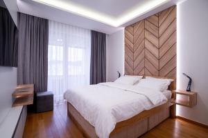 帕莱Apartman G8 Deluxe的一间卧室配有一张大床和木制床头板