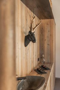 圣迈克尔隆高Das Liftplatzl的浴室设有水槽,墙上挂着鹿头