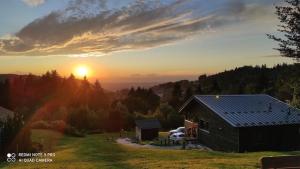 BelfahyChalet neuf avec jacuzzi privé, vue imprenable sur Massif des Vosges的山 ⁇ 在田野里,背靠日落