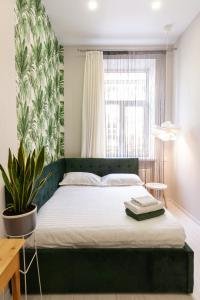 利沃夫温馨中央BV公寓的一间卧室设有一张绿色的床和一个窗户。