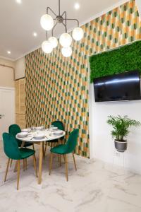 利沃夫温馨中央BV公寓的一间带桌子和绿色椅子的用餐室
