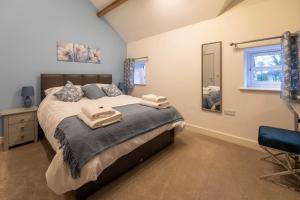 BodfariClwyd Cottage - Two Bed, Barn Conversion with Private Hot Tub的一间卧室配有一张大床和镜子