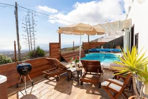 阿索马达Finca La Casita的一个带游泳池、椅子和遮阳伞的庭院