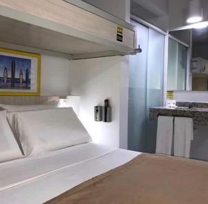 马塞约Expresso R1 Hotel Economy Suites的一间带白色床的卧室和一间厨房