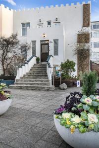 雷克雅未克城堡豪华公寓的前面有楼梯和鲜花的建筑