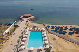 法耶兹Jewel Fayed Hotel的享有海滩的空中景致,设有游泳池和遮阳伞