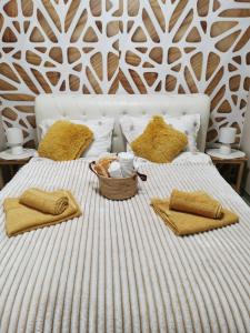 克鲁舍瓦茨Lux Apartman Krstic的一张带黄色枕头的床和一个篮子