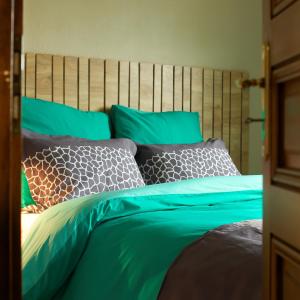 LeymenCOTTAGE-GITE COEUR DE SUNDGAU的一间卧室配有一张带绿床单和枕头的床。