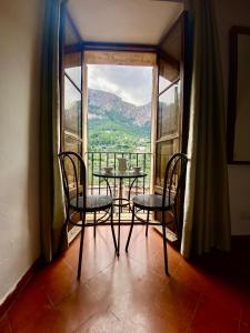 德阿Hostal Villa Verde-Adults Only的配有大窗户的客房内的桌椅