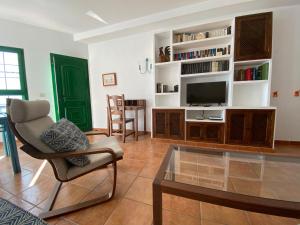 阿列塔Casa Bela的客厅配有电视、椅子和桌子
