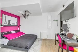 舍维伊拉吕Studio le petit baroque的卧室配有粉红色的床和书桌