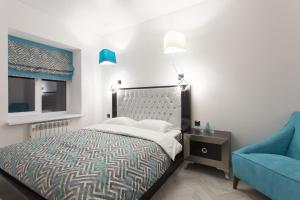 哈尔科夫Sumskaya Apartment Lux的一间卧室配有一张床和一张蓝色椅子