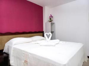 纳塔尔Marlymar Apart Pousada的卧室配有白色床和粉红色墙壁