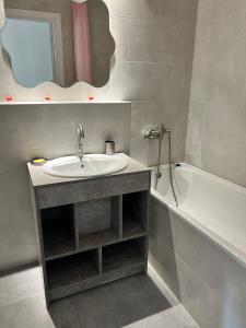 尤日内New Marine Apartment的浴室配有盥洗盆和浴缸。
