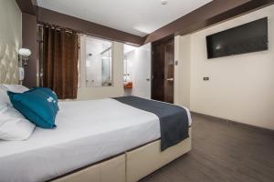 库斯科Olimpo Hotel Sauna & Spa的一间卧室配有一张大床和电视
