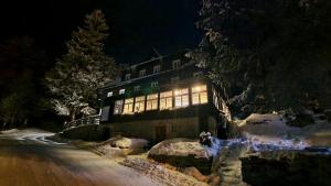 派克波特斯耐兹库德文酒店的一座晚上在雪中亮着灯的建筑