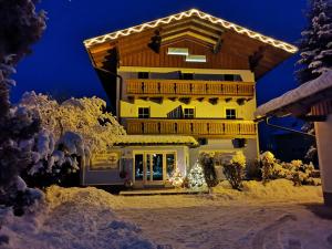 帕斯格许特路旁鲁斯巴赫Aparthotel Landhaus Schwaighofer的雪中带圣诞灯的房子