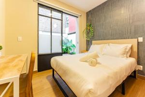 墨西哥城Casa Danubio near Reforma by VH的一间卧室配有一张床、一张桌子和一个窗户。