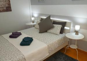 拉斯加莱塔斯Cosy Apartment 6 places Canarian Life的一间卧室配有带枕头的床铺和两张桌子