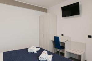 坎波巴索Residence Vazzieri的客房设有一张带书桌的床和一台电视。