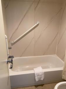 雷丁King's Inn Motel的带白色浴缸的浴室和卫生间