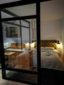 新瓦罗什Apartman Mali Raj Zlatar的一间卧室设有一张床和一个大型玻璃窗