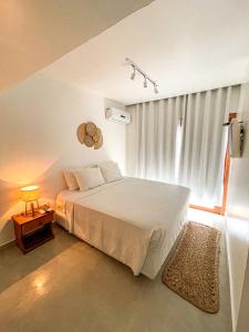 费尔南多 - 迪诺罗尼亚Pousada Brisa Mar的卧室配有白色的床和窗户。
