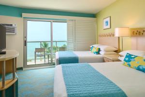 檀香山雅诗顿威基基环岛酒店的酒店客房设有两张床和一个阳台。