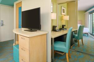檀香山雅诗顿威基基环岛酒店的客房设有一张桌子、一台电视和椅子